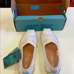Cream colored Toms slip on shoes.